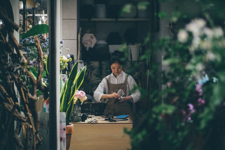 small business. lady in the background sorting flowers for a florist. flowers in the foreground out of focus. small business