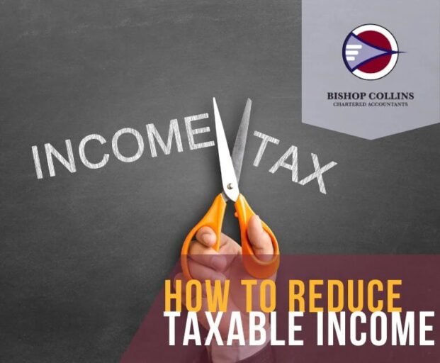 a hand cutting the words taxable income with scissors